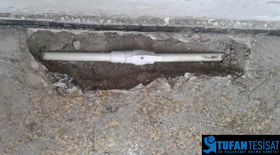 beton arasından su sızdıran boruyu onaran tesisatçı